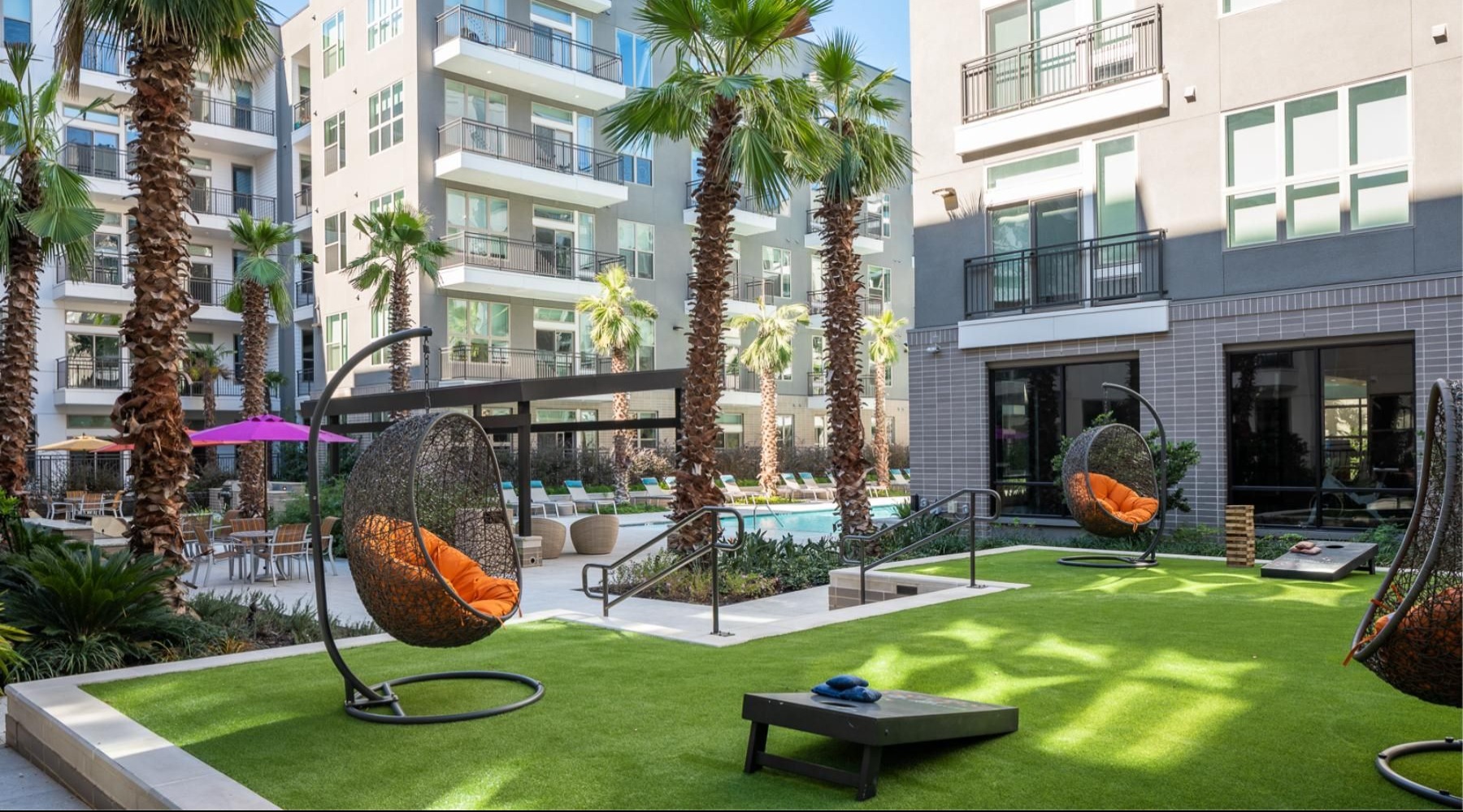 a lounge area with chairs and cornhole