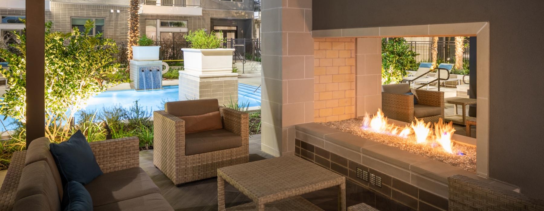 a lounge area with a fire pit, chairs and a pool